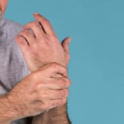 Mann hält sein Handgelenk vor Schmerzen