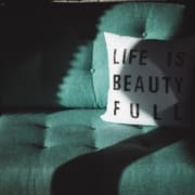 Der-echte-cbd-blog-wird-รl-brechen-mein-schnelles-Leben-ist-schรถn Grรผnes Sofa mit einem weiรen Kissen mit der Aufschrift "Das Leben ist schรถn".