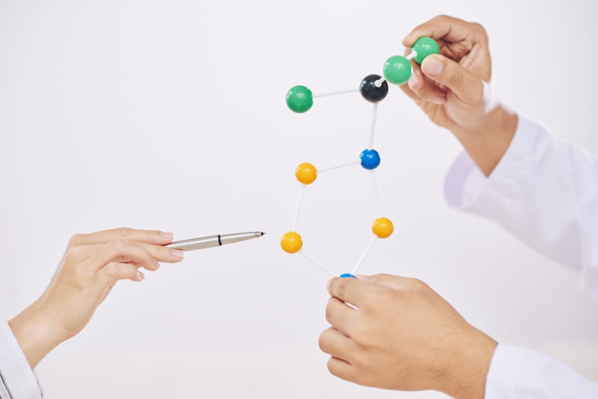 Wissenschaftler erklären von Hand, ein Plastikmodul aus Molekülen
