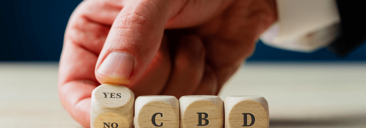 Man spelt met de hand JA CBD in houten dobbelstenen
