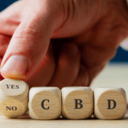 The-real-cbd-blog-cbd-für-muskel-dystrophie-was-man-wissen-muss Mann buchstabiert mit der Hand YES CBD in Holzwürfeln