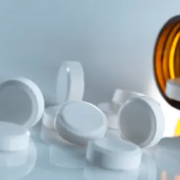 The-Real-CBD-Blog-Cab-you-take-CBD-with-painkillers White tablets falling out of a brown glass