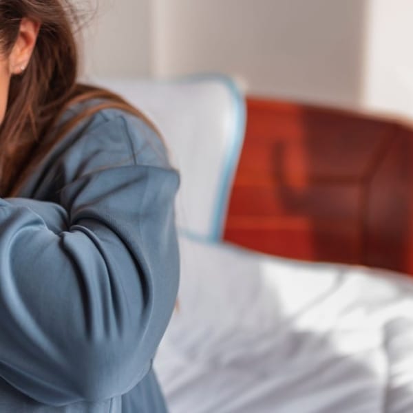 Huilend meisje zittend op een bed