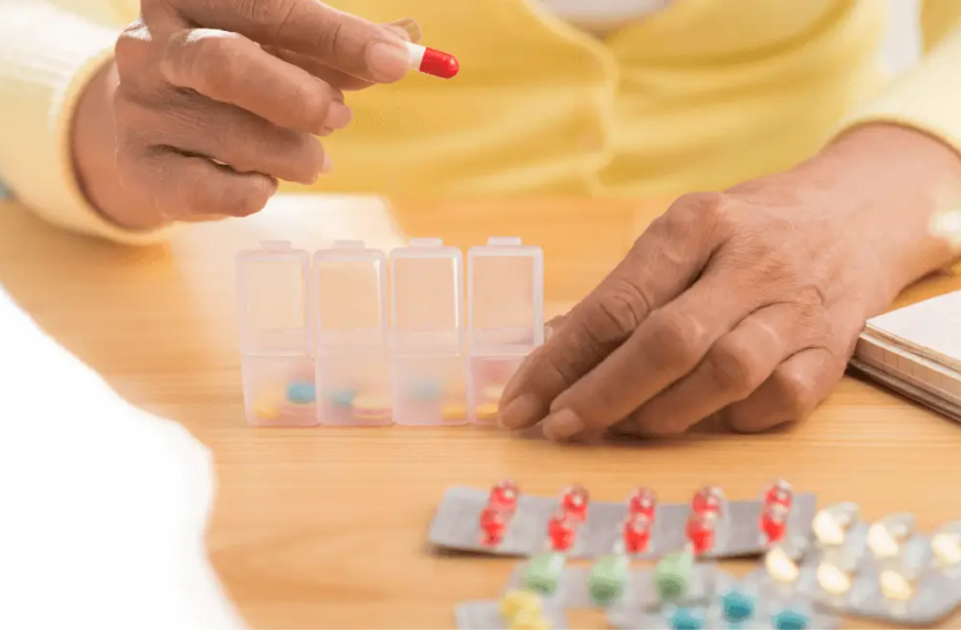 Hands putting pills in to pill organiser