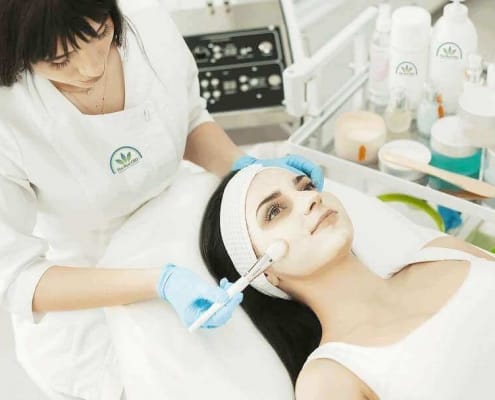 Schoonheidsspecialiste geeft een vrouw een gezichtsbehandeling in een schoonheidssalon