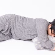 The-Real-CBD-Blog-CBD-mit-Entzugssymptomen Auf dem Boden schlafende Person in grauem Pyjama