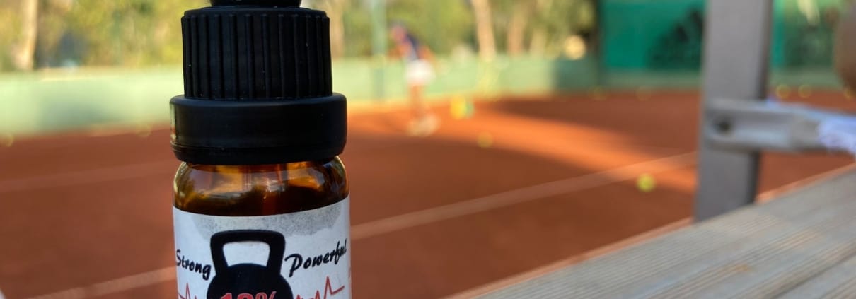 Die Real CBD-Tinktur auf dem Hintergrund eines Tennisplatzes