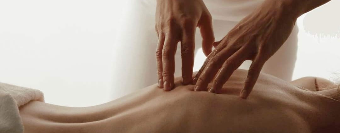Hands massaging the back of a woman