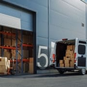 CBD-Großhandel_Industrie_Europa_UK Weißer Lieferwagen mit offenen Türen vor einem Lagerhaus