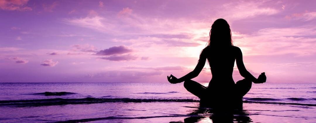 Woman in yoga pose on the seashore