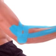 Der-Real-CBD-Blog-CBD-für-Tendonitis Mann hält einen Schläger mit kinesiologischem Klebeband am Ellbogen