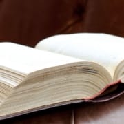 Die-Real-CBD-CBD 101-Anfänger-Leitfaden-zur-Verwendung-von-CBD-als-Schmerzlinderung Großes Buch aufgeschlagen auf einem Ledersofa