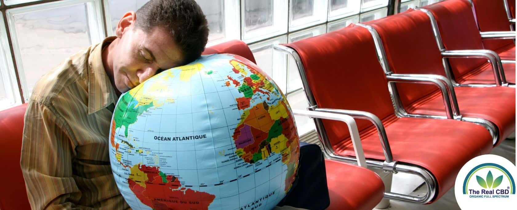 Man slaapt met zijn hoofd op een wereldbol op een vliegveld