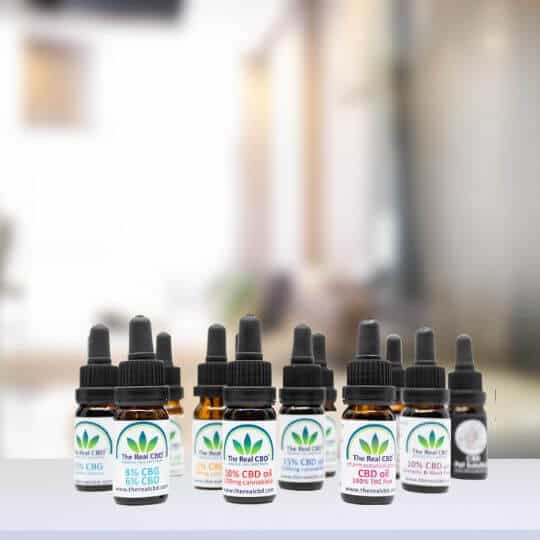 Reihe von CBD-Tinkturflaschen auf einer Tischplatte - The Real CBD Brand