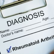 Der-Real-CBD-Blog-CBD-für-Rheumatoide-Atrhritis Arzt hält Klemmbrett mit rheumatoider Arthritis Diagnose auf