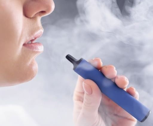 CBD vape Person vaping on a blue vapepen blowing smoke