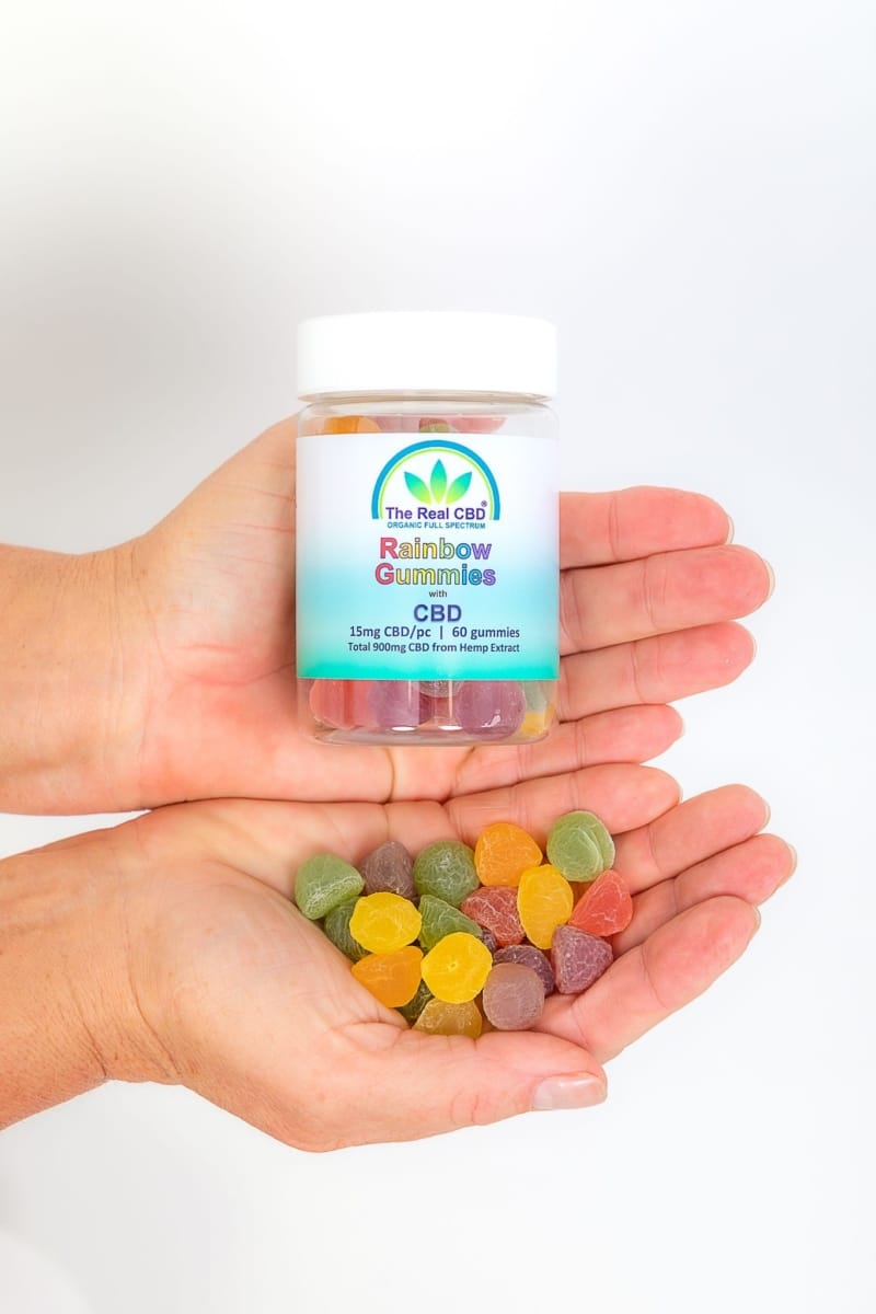 15mg CBD rainbow gummies and jar in hands - The Real CBD Brand