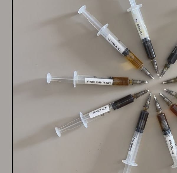10 spuiten in een cirkel die verschillende kleuren CBD-olie demonstreren