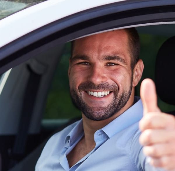 Man geeft duim omhoog in auto