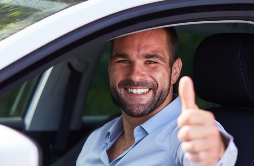 Man gives thumbs up in a car