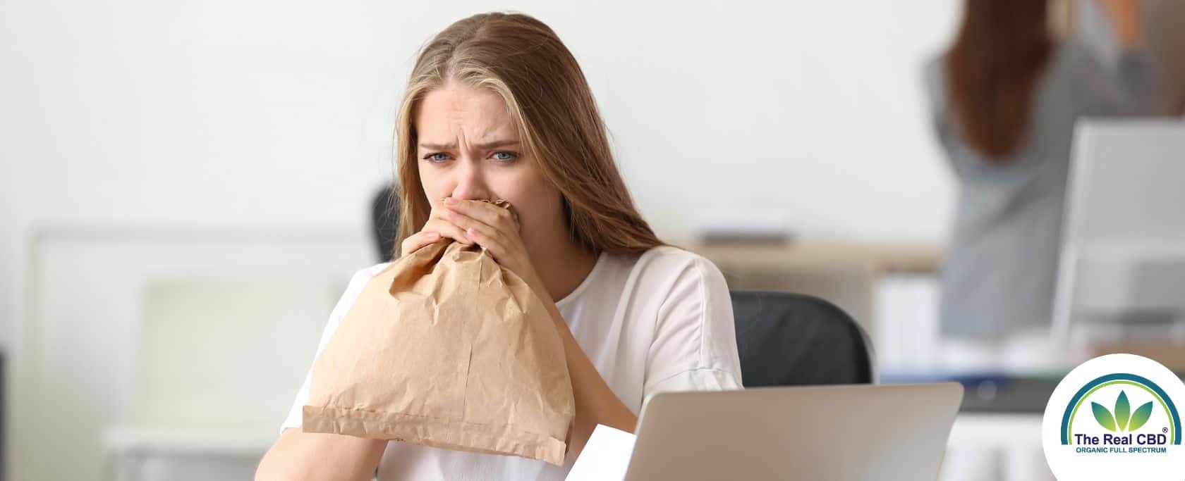 Vrouw blaast in een paperbag in een kantoor