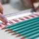 Potloden en paperclips in nette lijnen leggen met liniaalvingers om het te ordenen
