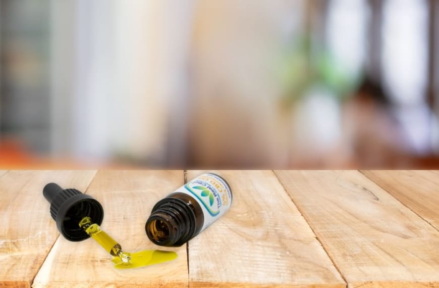 Omgevallen CBD-fles met uitgelopen olie in beeld.