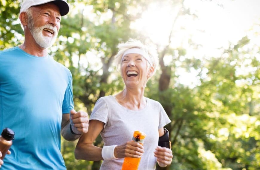 Happy old couple running in the forrest