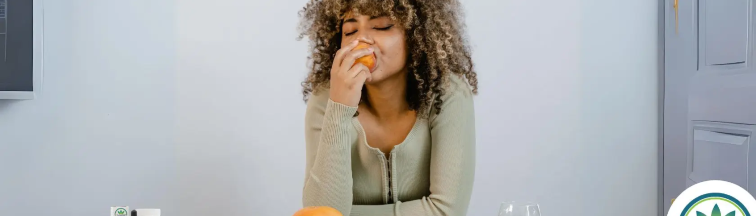 Woman enjoying a peach at a dinner table