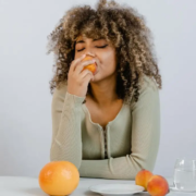 The-Real-CBD-Blog-kannst-du-CBD-auf-leeren-Magen-essen Frau genieรt einen Pfirsich am Esstisch