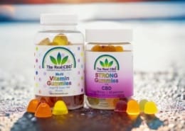 2 CBD gummi jars on cement surface - The Real CBD Brand