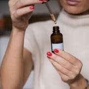 The-Real-CBD-Blog-kann-ich-CBD-vor-der-Arbeit-nehmen Frau mit Tropfflasche nimmt vor der Arbeit Öl ein