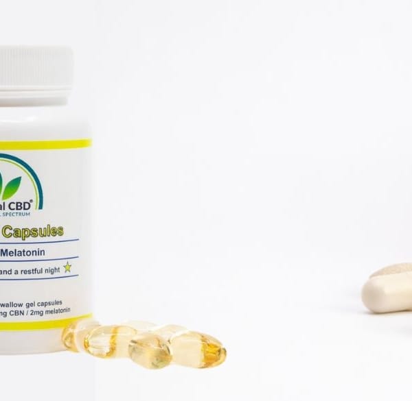 Mix van vitaminen uit een gekanteld glas en The Real CBD-olie