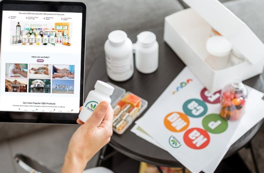 Man met een tablet met The Real CBD website erop en een potje The Real CBD tabletten