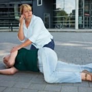 The-Real-CBD-Blog-CBD-for-Seizures Frau ruft um Hilfe für eine Person am Boden, die einen Krampfanfall hat