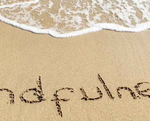 Kustplaatsen met MINDFULNESS in het zand geschreven