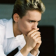 Man sitting starring nervously into the ground