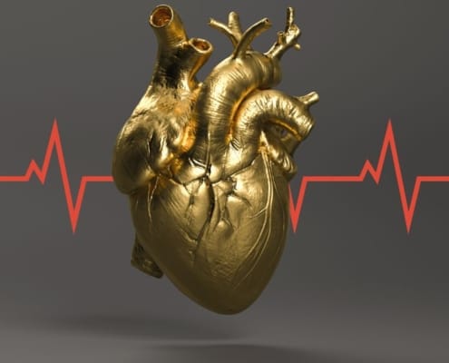 Een gouden menselijk hart met rode EKG-lijn erdoorheen