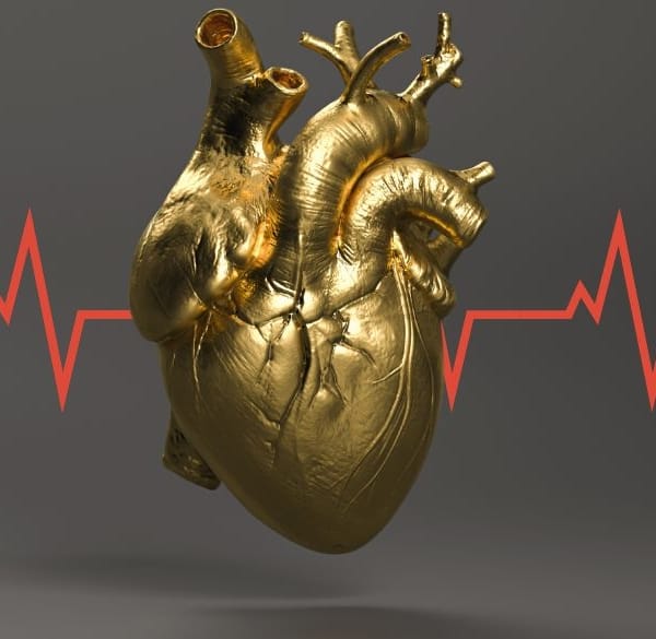 Een gouden menselijk hart met rode EKG-lijn erdoorheen