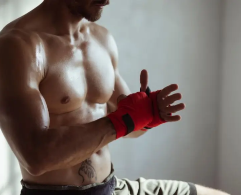 Mann wickelt seine Hand zum MMA-Kampf