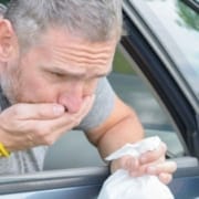 Echte-CBD-Blog-CBD-voor-motieziekte-mensen-en-honden Een man braakt uit een autoraam