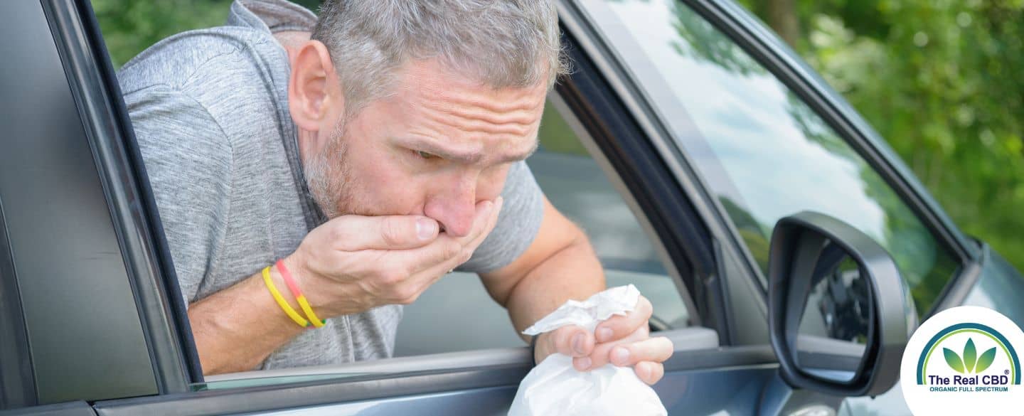 Ein Mann erbricht aus einem Autofenster