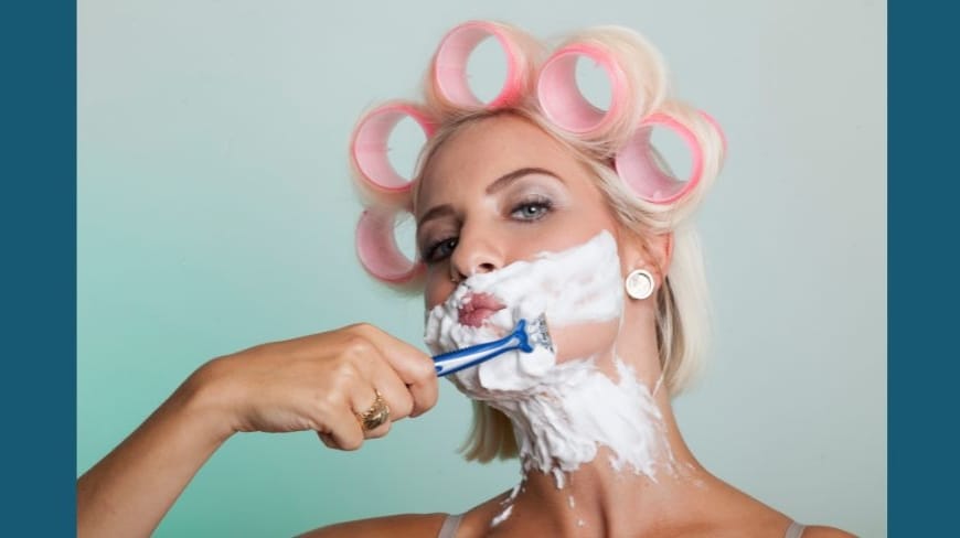 Femme avec des bigoudis se rasant la barbe
