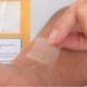 Person putting a CBD pain patch on her arm