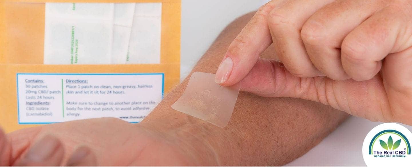 Person, die ein CBD-Schmerzpflaster auf ihren Arm klebt