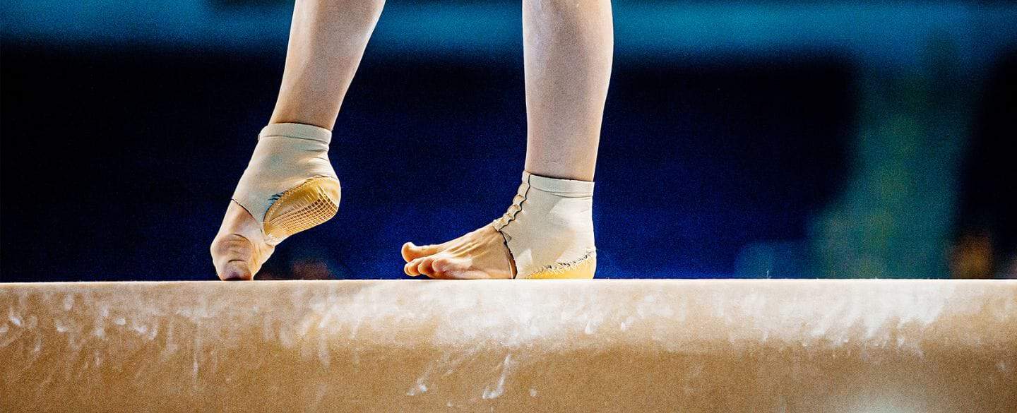 A gymnasts feet on the bar