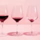 Eine Reihe von Weingläsern mit immer weniger Rotwein darin