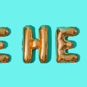 HE HE Y buchstabiert in goldenen Luftballons