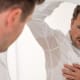 Man looking at his sweaty armpits in the mirror