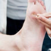 Der-real-cbd-blog-cbd-für-neuropathie Arzt testet Nervenreaktion unter dem Fuß eines Patienten